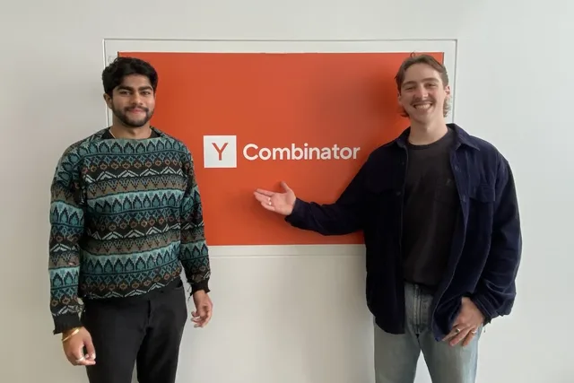 Landseer Enga and Anam Hira standing beside the Y Combinator sign